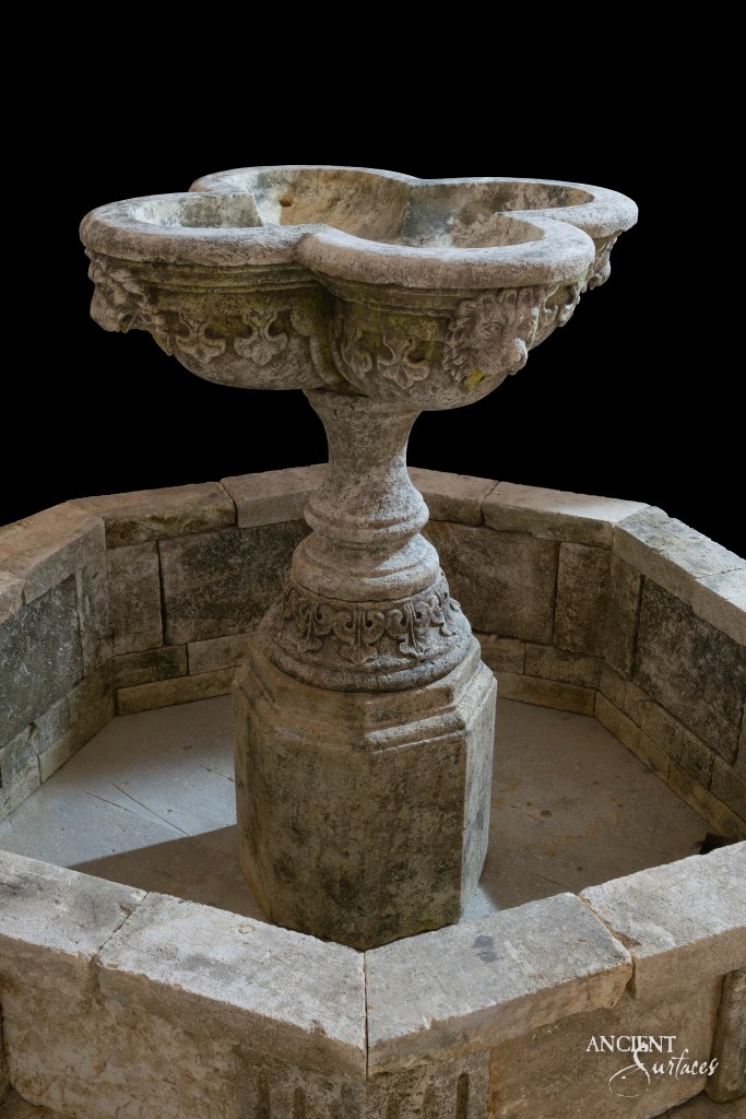 elegant Limestone pool fountain by Ancient Surfaces, its intricate details and warm glow serving as a testament to the company's commitment to quality and authenticity.