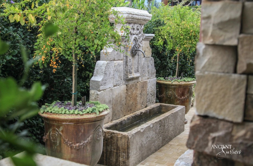 Antique Stone Wall Fountains, 
Old Water Fountains for Sale
An antique stone wall fountain nestled in a lush garden antique weathered surface 
Ancient Surfaces